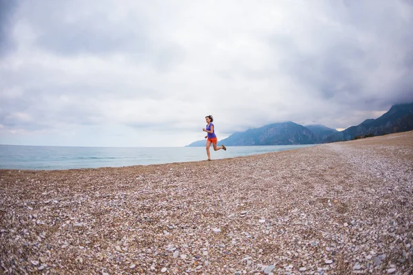 La chica corre por la playa de arena . —  Fotos de Stock