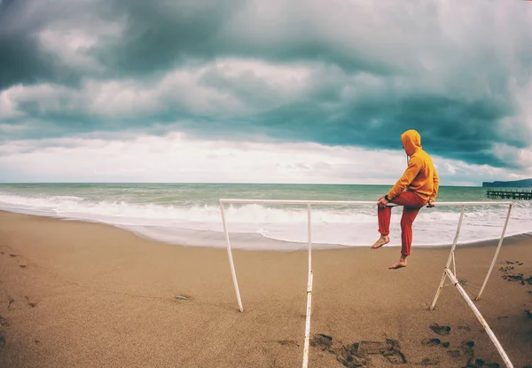 Um homem senta-se na praia num dia ventoso . — Fotografia de Stock