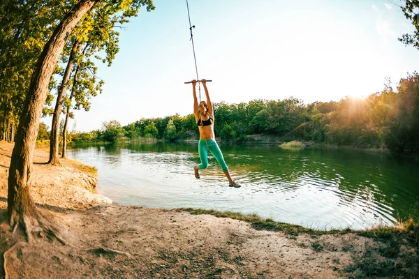 A woman is riding a swing.