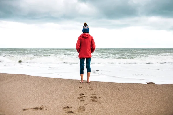 Mulher descalça olha para o mar de inverno . — Fotografia de Stock