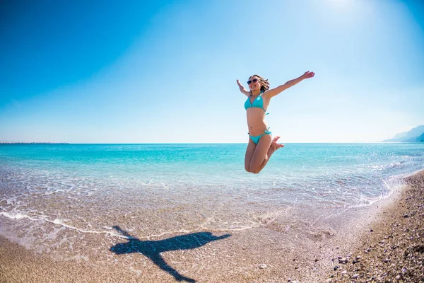 Chica en traje de baño saltando en la playa . —  Fotos de Stock