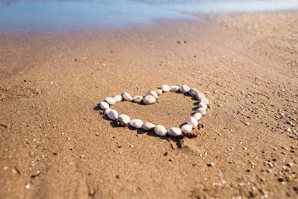 Coração de seixos na areia . — Fotografia de Stock