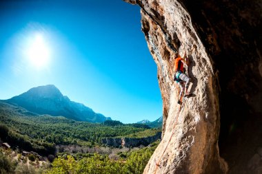 Güzel dağlar ve mavi gökyüzü arka planda kaya tırmanıcı.