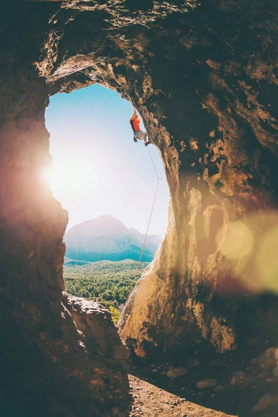 Bergsteiger klettert in die Höhle. — Stockfoto