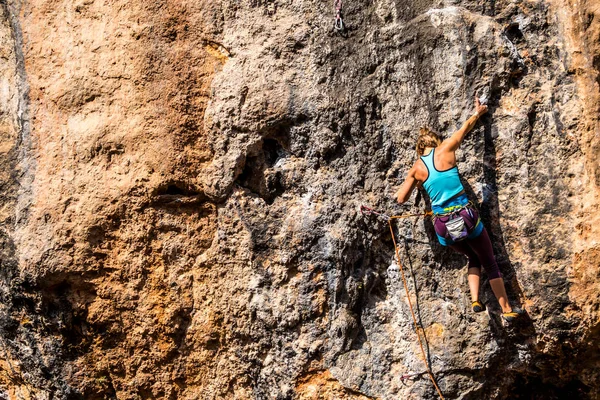 Ein Mädchen erklettert einen Felsen. — Stockfoto