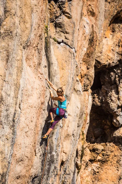 Ein Mädchen erklettert einen Felsen. — Stockfoto