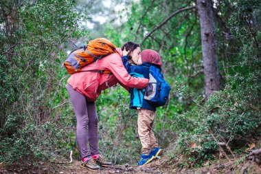 Orman yoluyla oğluyla bir kadın yürüyor. 