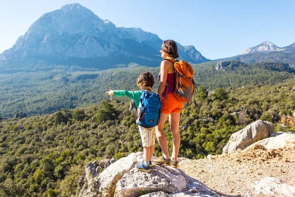 Pojken och hans mamma står på toppen av berget. — Stockfoto