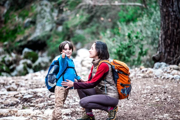 Una mujer camina con su hijo por el bosque . — Foto de Stock