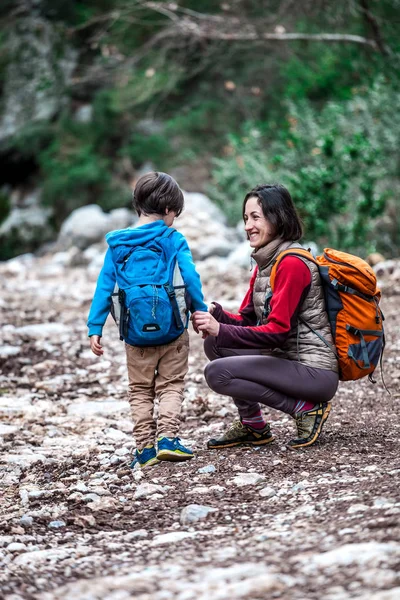 Uma mulher caminha com seu filho pela floresta . — Fotografia de Stock