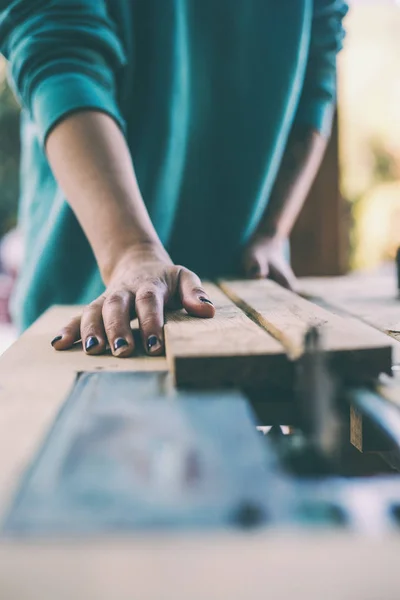 Una mujer trabaja en un taller de carpintería . — Foto de Stock