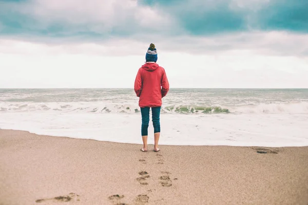 Mujer descalza mira el mar de invierno . — Foto de Stock