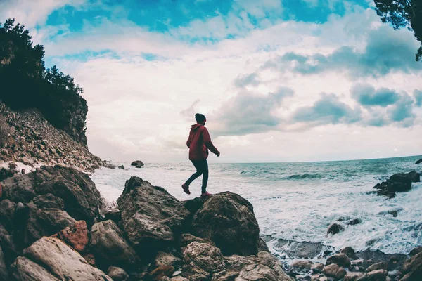 那个女孩站在海边的一块石头上. — 图库照片