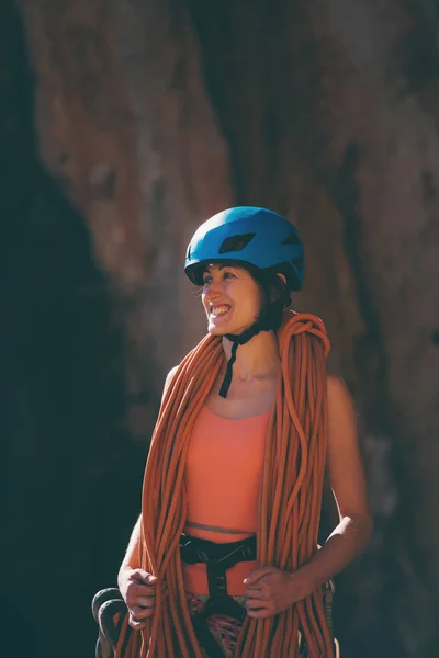 Escalador em um capacete olha para uma parede de pedra . — Fotografia de Stock