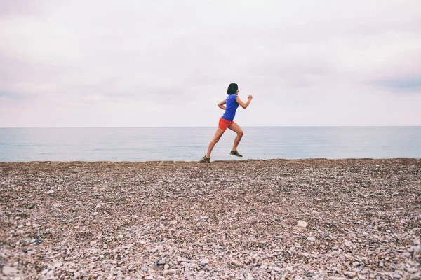 Το κορίτσι που τρέχει κατά μήκος της αμμώδους παραλίας. — Φωτογραφία Αρχείου