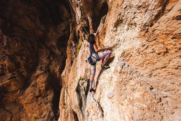 A girl climbs a rock. — Stock Photo, Image