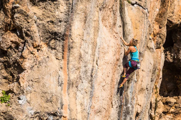Een meisje klimt op een rots. — Stockfoto