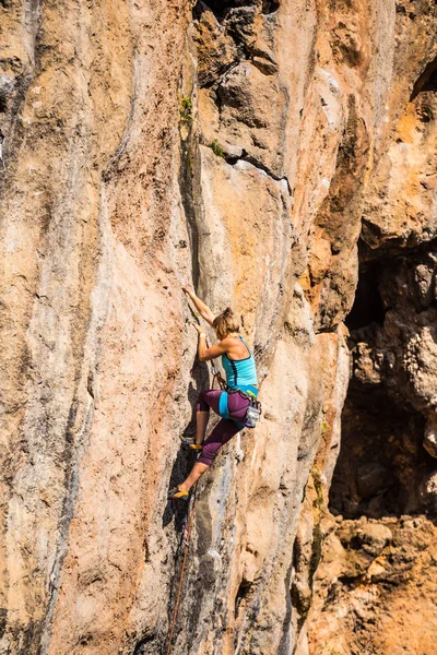 Ein Mädchen erklettert einen Felsen. — Stockfoto