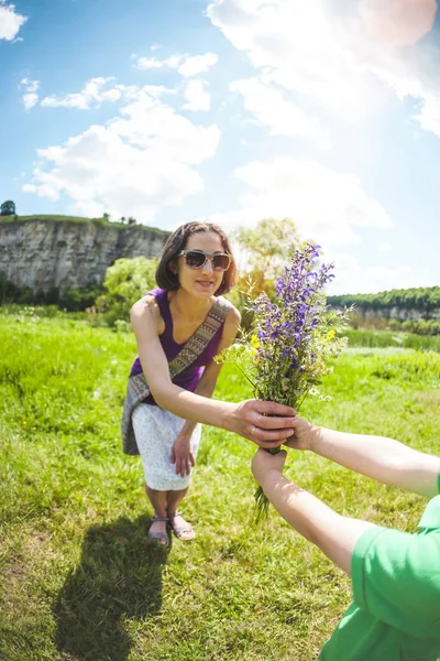 The boy gives his mother a bouquet of flowers.