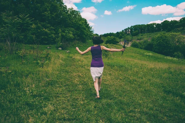 Het meisje loopt over het veld. — Stockfoto