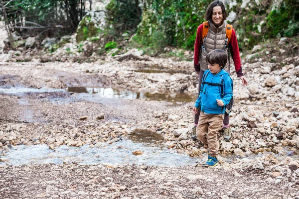 Uma mulher caminha com seu filho pela floresta . — Fotografia de Stock