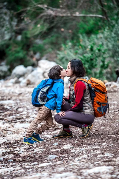 Una donna cammina con suo figlio attraverso la foresta . — Foto Stock