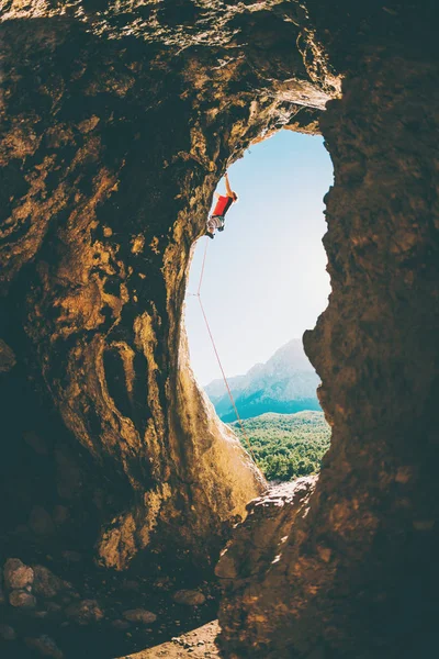 Bergsteiger klettert in die Höhle. — Stockfoto