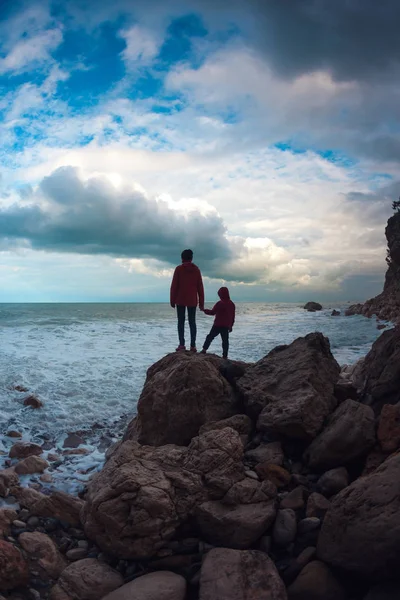 女と海と空に対して子供のシルエット. — ストック写真