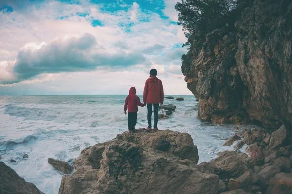 一个妇女和一个孩子的剪影反对海和天空. — 图库照片