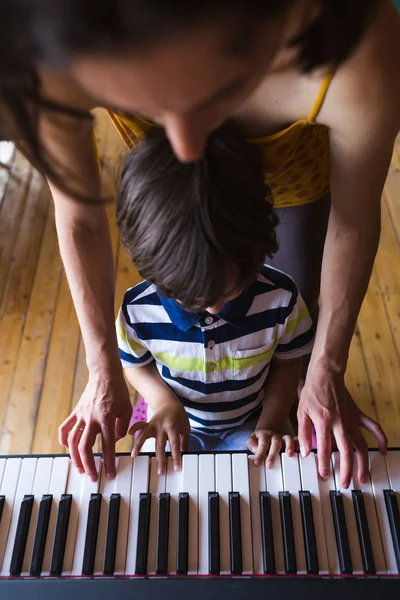 Manos de niños y mujeres en las teclas de piano . — Foto de Stock