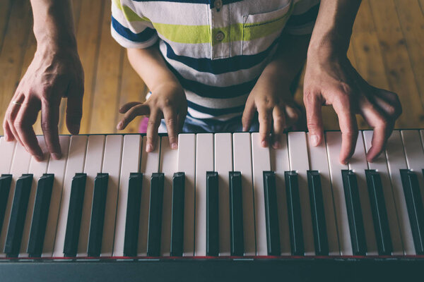 Children's and women's hands on the piano keys. Stock Image