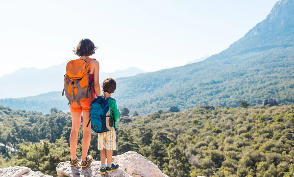 Pojken och hans mamma står på toppen av berget. — Stockfoto