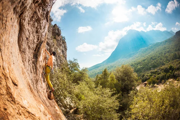 Un hombre trepa una roca . — Foto de Stock