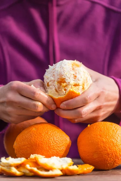 Woman peels oranges from peel. — Stock Photo, Image