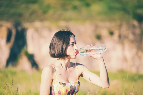 A menina bebe água de uma garrafa . — Fotografia de Stock