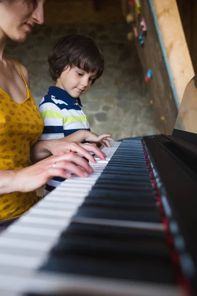 Manos de niños y mujeres en las teclas de piano . — Foto de Stock