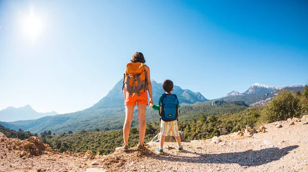 Pojken och hans mamma står på toppen av berget. — Stockfoto