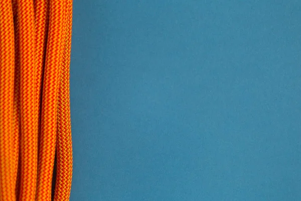 Corda arancione per arrampicarsi su uno sfondo blu . — Foto Stock