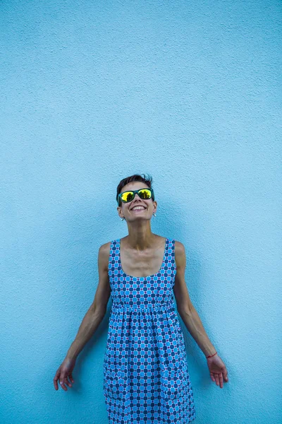 Woman against a blue wall.