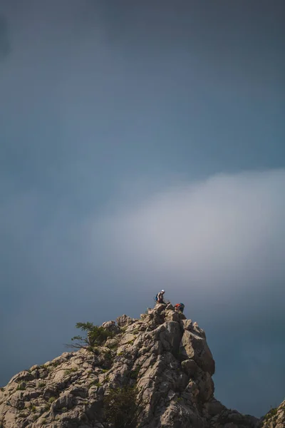 two climbers climb to the top of the mountain.