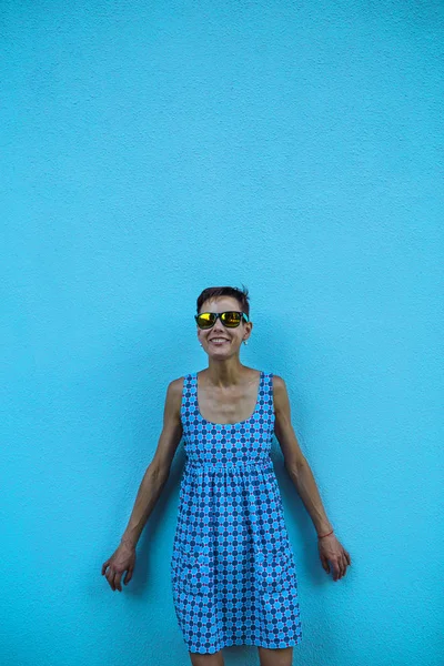 Mujer contra una pared azul . —  Fotos de Stock