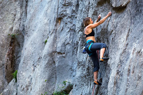 A girl climbs a rock. — Stock Photo, Image