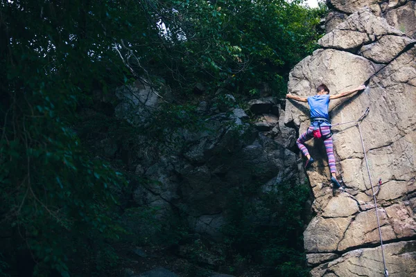 La fille grimpe le rocher de granit . — Photo