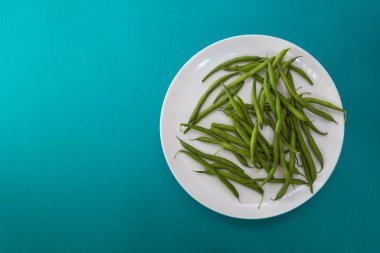 Beyaz tabakta kuşkonmaz fasulyesi.