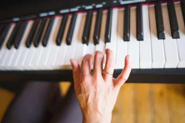 Una mujer aprende a tocar el piano . — Foto de Stock