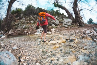 Yalınayak kız dağ nehrini geçti.