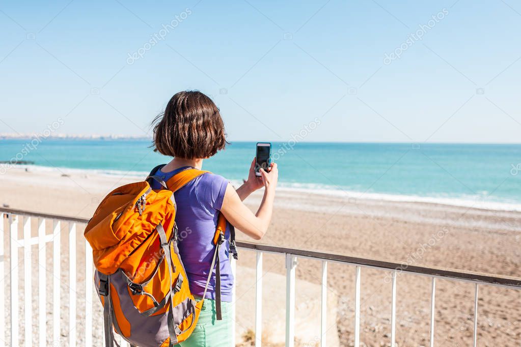 A girl takes a selfie on the beach.