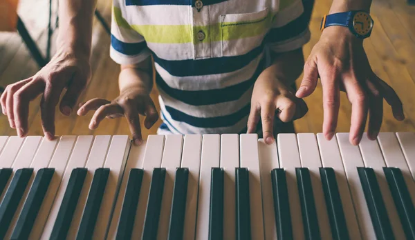 Kinderen en vrouwenhanden op de piano toetsen. — Stockfoto