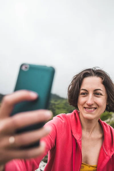 Kobieta bierze selfie na szczycie góry. — Zdjęcie stockowe