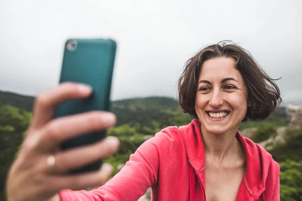 Kobieta bierze selfie na szczycie góry. — Zdjęcie stockowe